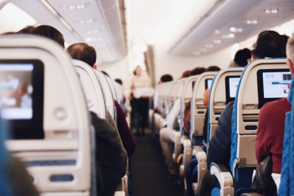 Airplane interior with rows full of passengers.