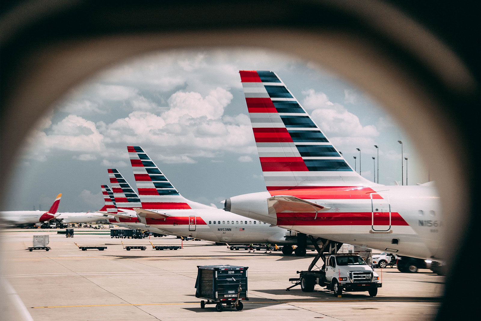 Tails of parked airplanes seen from an airplane window.